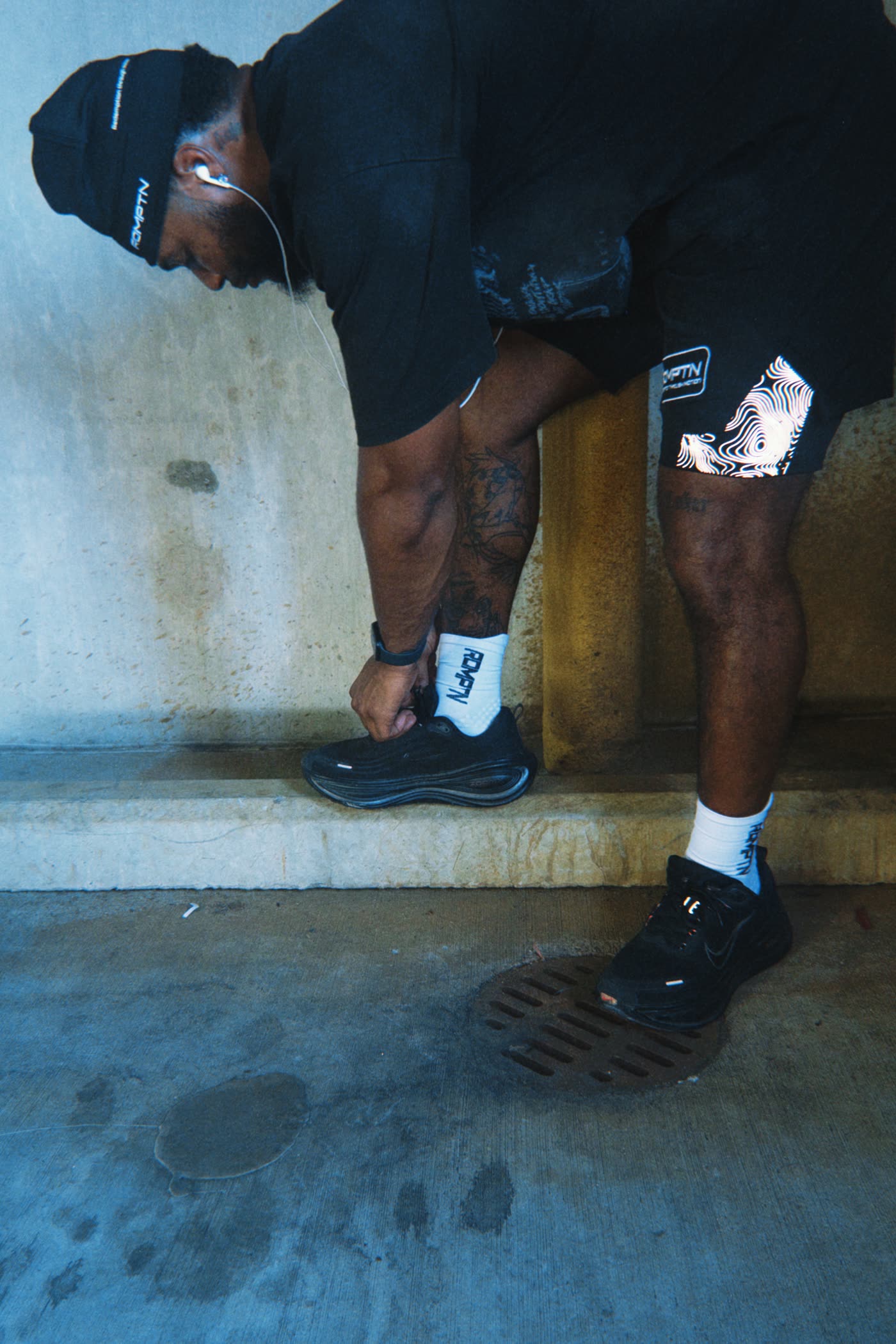 A member lacing his running shoes in a concrete stairwell