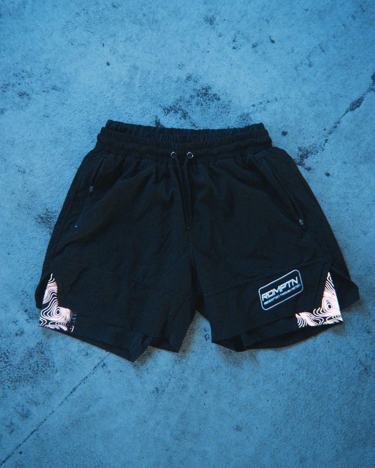 RDMPTN double-layer shorts in black with reflective topographic panels